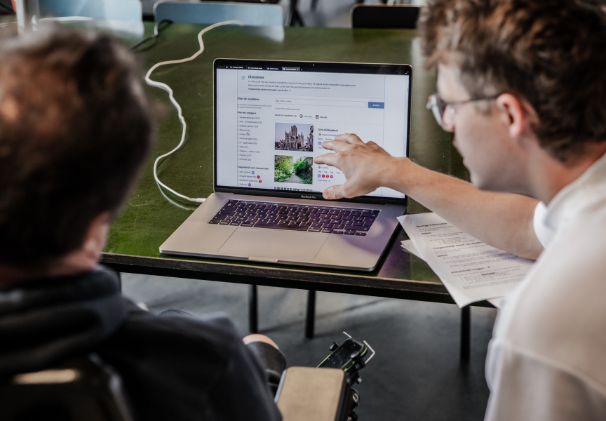 Two people looking at a laptop's screen 